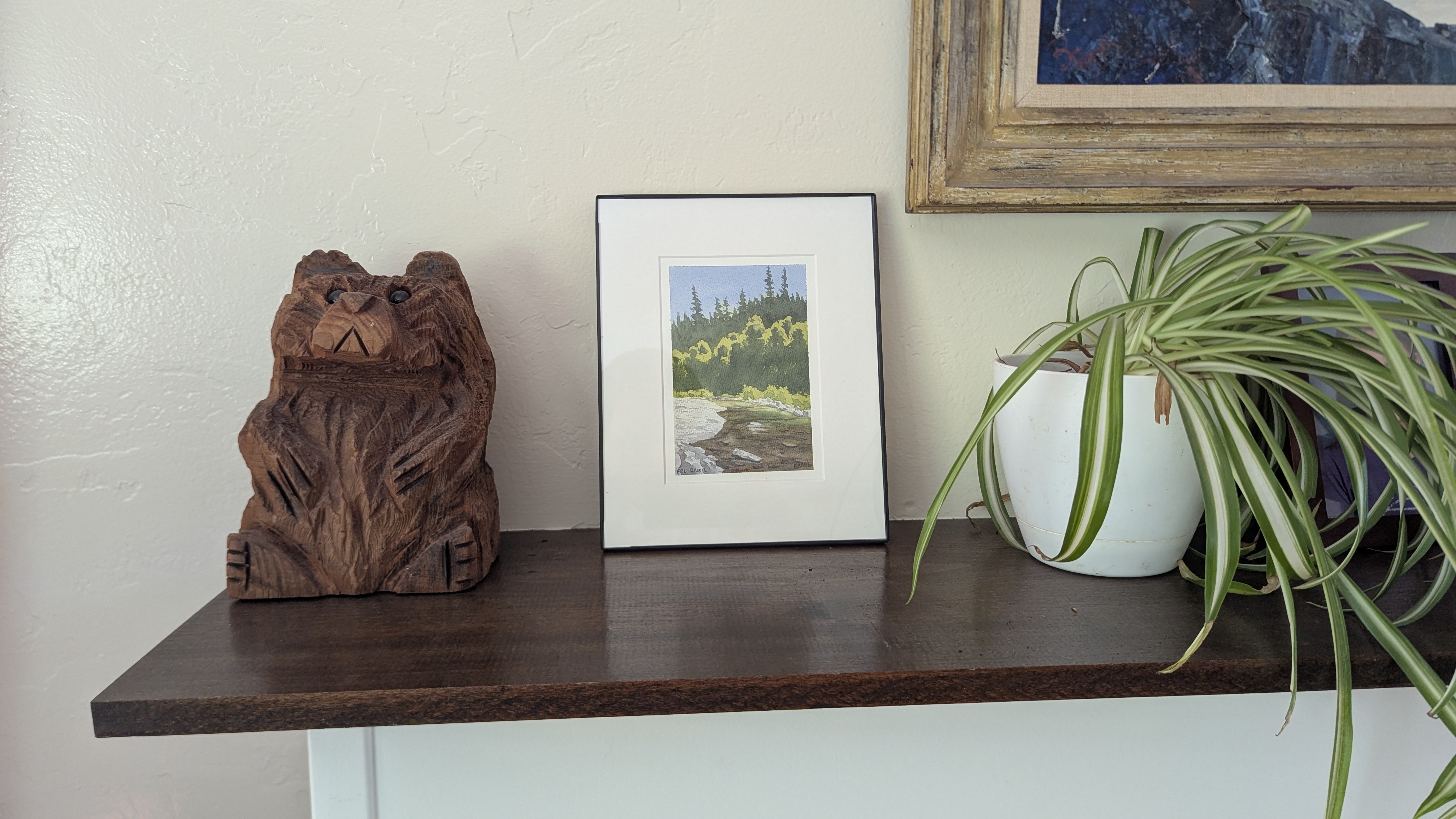 Small watercolor painting of the Eel River sitting on a mantel.