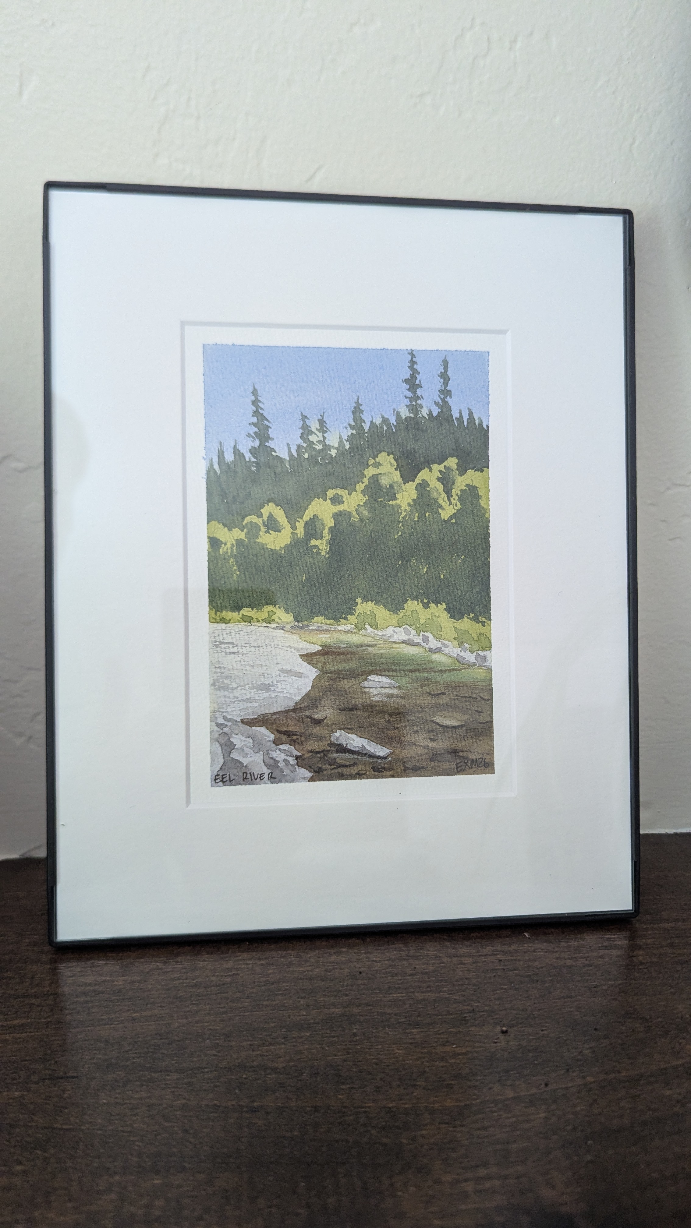 Watercolor painting of the beach at Fort Bragg, CA sitting on a mantel.