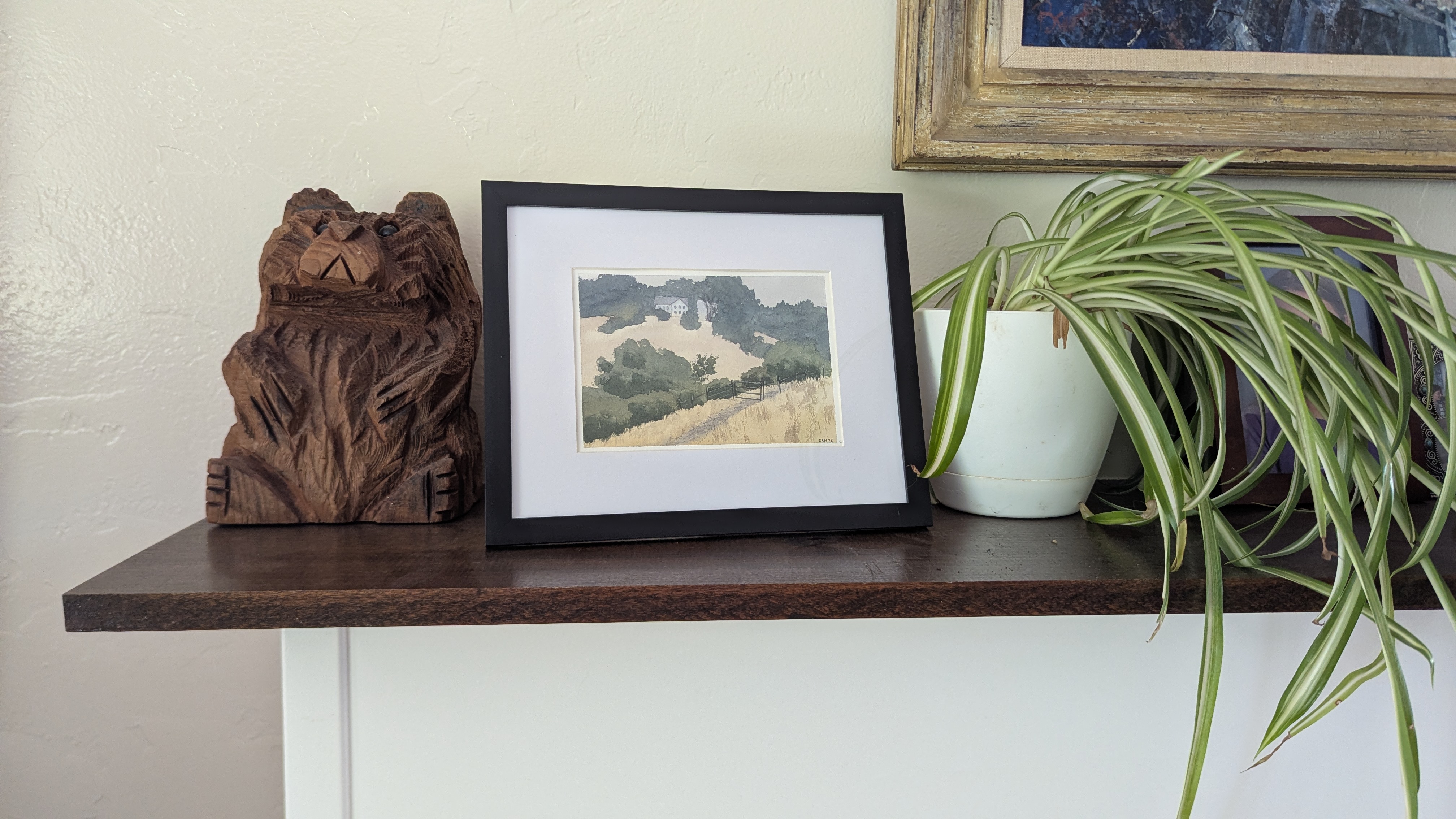 Watercolor painting of a house on a hill in Joseph D. Grant County Park sitting on a mantel.